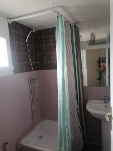 a bathroom with a shower curtain and a sink at Proche de la plage les hauts du port in Saint-Cyr-sur-Mer