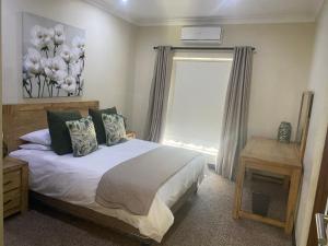 a bedroom with a large bed and a window at Riverfront Golf Estate House in Parys +26 photos