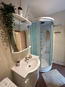 a white bathroom with a sink and a mirror at Villa ARB in Juodkrantė