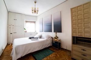 a bedroom with a large white bed and a chandelier at Awesome apartment center Valencia in Valencia