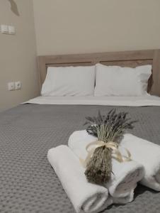 Una cama con toallas y un ramo de flores. en Δ5-Τα διαμερίσματα του δασκάλου, en Filiatra