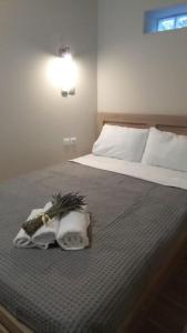 Un dormitorio con una cama con zapatos y toallas. en Δ5-Τα διαμερίσματα του δασκάλου, en Filiatra