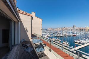 uma varanda com cadeiras e uma marina com barcos em Sublime Pépite Vieux Port 2p Vue Imprenable em Marselha