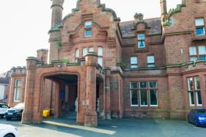 an old red brick building with an arch entrance at Adamton Country House Hotel in Prestwick