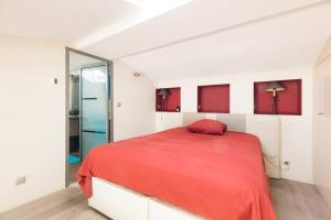 una camera bianca con un letto rosso e una porta in vetro di Sublime Pépite Vieux Port 2p Vue Imprenable a Marsiglia