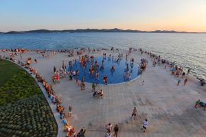 a crowd of people standing around a pool in the water at Apartman Fortuna in Zadar