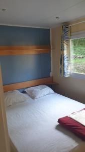 a bedroom with a large bed with a window at Camping Le Pré Cathare in Lavelanet