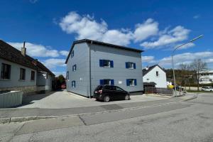 a car parked in front of a blue building at Apartment mit Burgblick in Burglengenfeld