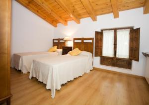 two beds in a room with wooden floors at El Molino de la Hiedra in Albeta