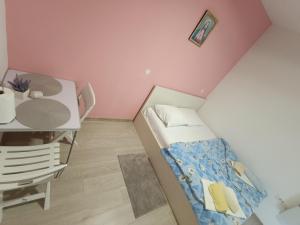 Habitación pequeña con cama y escritorio. en Rooms Mario, en Međugorje