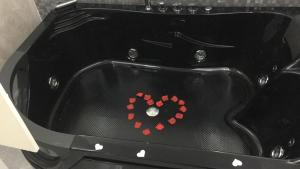 a black bath tub with a heart painted on it at Le rocce nere in Giardini Naxos
