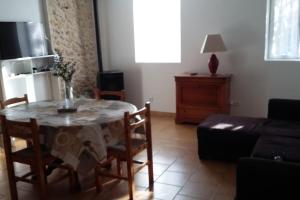 een woonkamer met een tafel met stoelen en een bank bij CHARMANTE MAISON PAISIBLE 6 PERSONNES in Vendays-Montalivet
