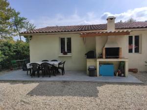a patio with a table and chairs in front of a house at CHARMANTE MAISON PAISIBLE 6 PERSONNES in Vendays-Montalivet