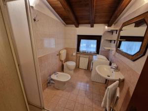 ein Badezimmer mit einem WC, einem Waschbecken und einem Spiegel in der Unterkunft Country house Dolce Nocciola in Vignanello