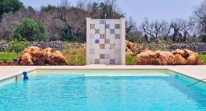 une piscine avec un chien dans l'eau à côté d'un mur dans l'établissement Villa Marzoni con Piscina Privata by HDSalento, à Tiggiano
