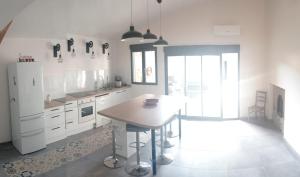 uma cozinha com uma mesa e um frigorífico em Vacances canal du midi em Ouveillan