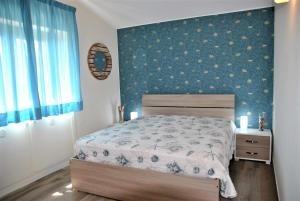 um quarto com uma cama e uma parede azul em CASA DINKY Attico con terrazza vista mare em Formia