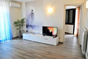 uma sala de estar com uma televisão de ecrã plano num armário branco em CASA DINKY Attico con terrazza vista mare em Formia