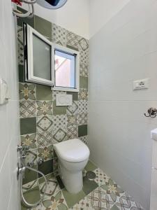 a bathroom with a toilet and a window at Mini villino Ladispoli Centro Mare in Ladispoli
