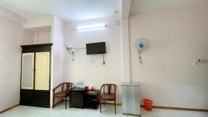 a room with a table and chairs and a tv at Saigon PT Hotel in Ấp Bình Hưng