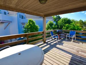 a deck with two chairs and a table and a grill at Surf Club Oceanfront Hotel in Dewey Beach