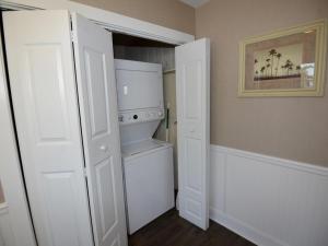 a kitchen with white cabinets and a white refrigerator at Surf Club Oceanfront Hotel in Dewey Beach