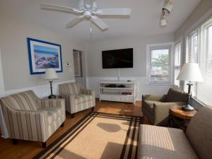 a living room with a couch and a flat screen tv at Surf Club Oceanfront Hotel in Dewey Beach
