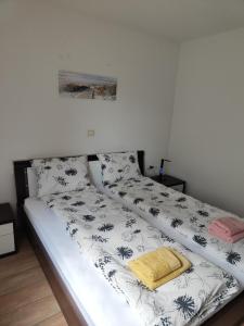 a bed with a black and white blanket on it at Apartma Nena in Bovec