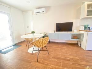 uma sala de estar com uma televisão e uma mesa e cadeiras em Setubal Beach Vibes - Pátio em Setúbal