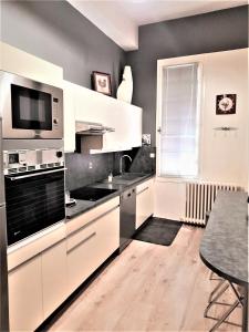 a kitchen with black and white appliances and a table at PIED A TERRE DE CHARME in Albi