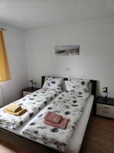 een bed met zwarte en witte lakens en kussens bij Apartma Nena in Bovec