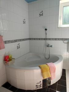 een wit bad in een wit betegelde badkamer bij Apartma Nena in Bovec