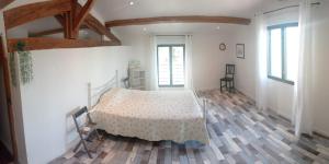 Schlafzimmer mit einem Bett und Holzboden in der Unterkunft Vacances canal du midi in Ouveillan
