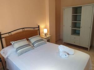 1 dormitorio con 1 cama blanca y 2 almohadas en Apartamento Primera Línea de Playa Port-Segur, en Segur de Calafell