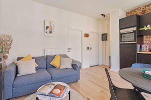 a living room with a blue couch and a table at New renovated condo's @ trendy south in Antwerp