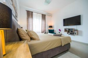 a bedroom with a large bed with a flat screen tv at Luxury rooms Alice in Split