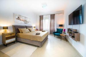 a bedroom with a bed and a tv and a chair at Luxury rooms Alice in Split