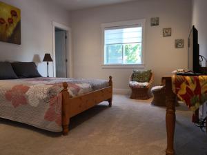 1 dormitorio con cama y ventana en DELOVELY B&B, en White Rock
