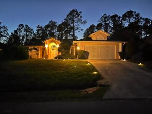 ein Haus mit einer nachts beleuchteten Garage in der Unterkunft Grandma’s White House in Palm Coast