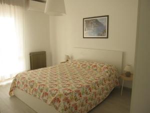 a bedroom with a bed with a flowered blanket at Appartamento Ariston in Lido