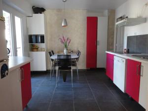 eine Küche mit roten Schränken und einem Tisch mit Stühlen in der Unterkunft Beautiful house near the beach, 4 bedrooms in Bidart