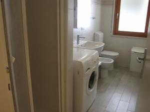 a bathroom with a washing machine and a sink at Appartamento Ariston in Lido +24 photos
