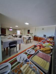 una cafetería con mesas y platos de comida expuestos en Pousada Coqueiral en Aracruz