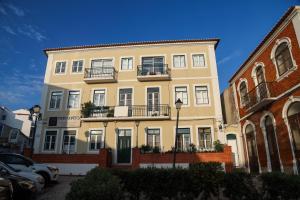 a large yellow building with balconies on a street at Silver Coast Retreat in Nazaré