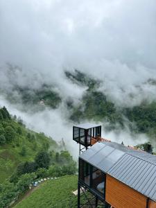 a house on top of a mountain in the clouds at Northland Bungalows in Çayırdüzü