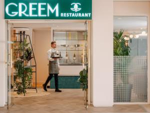 a man standing in front of a green restaurant sign at Novotel Paris Centre Tour Eiffel in Paris