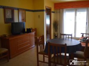 Sala de estar con mesa de comedor y TV en Apartamento 1ª linea en Marina D´or, Oropesa del Mar, en Oropesa del Mar
