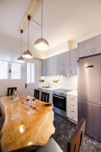 Una cocina con una mesa de madera y un refrigerador. en Lefkada white house, en Lefkada