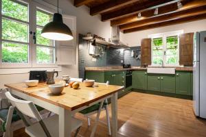 a kitchen with a wooden table and green cabinets at Casa escondida cuencu in Margolles