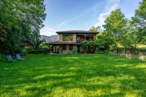 a house with a large yard with green grass at Casa escondida cuencu in Margolles